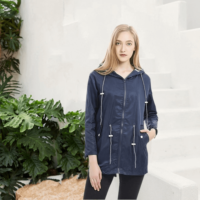 Woman wearing a blue waterproof hooded rain long jacket, perfect for windproof outdoor activities. Model SF0078.